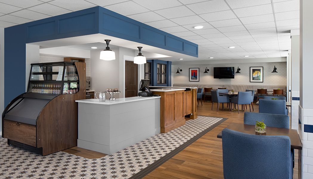A modern lobby with a reception desk and seating area, featuring blue accents and stylish lighting fixtures.