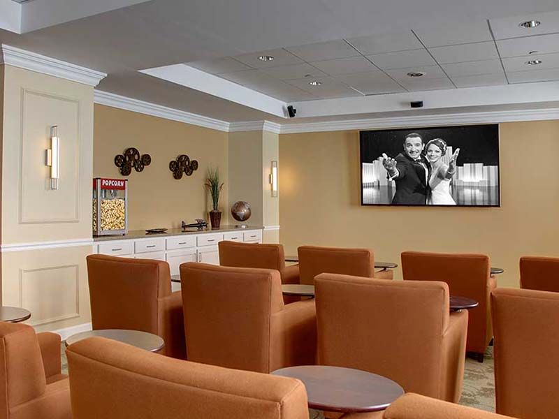 A modern lounge area with comfortable seating and a large screen for presentations.