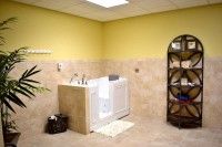 A modern bathroom with a walk-in bathtub and tiled walls, featuring a shelving unit for storage.