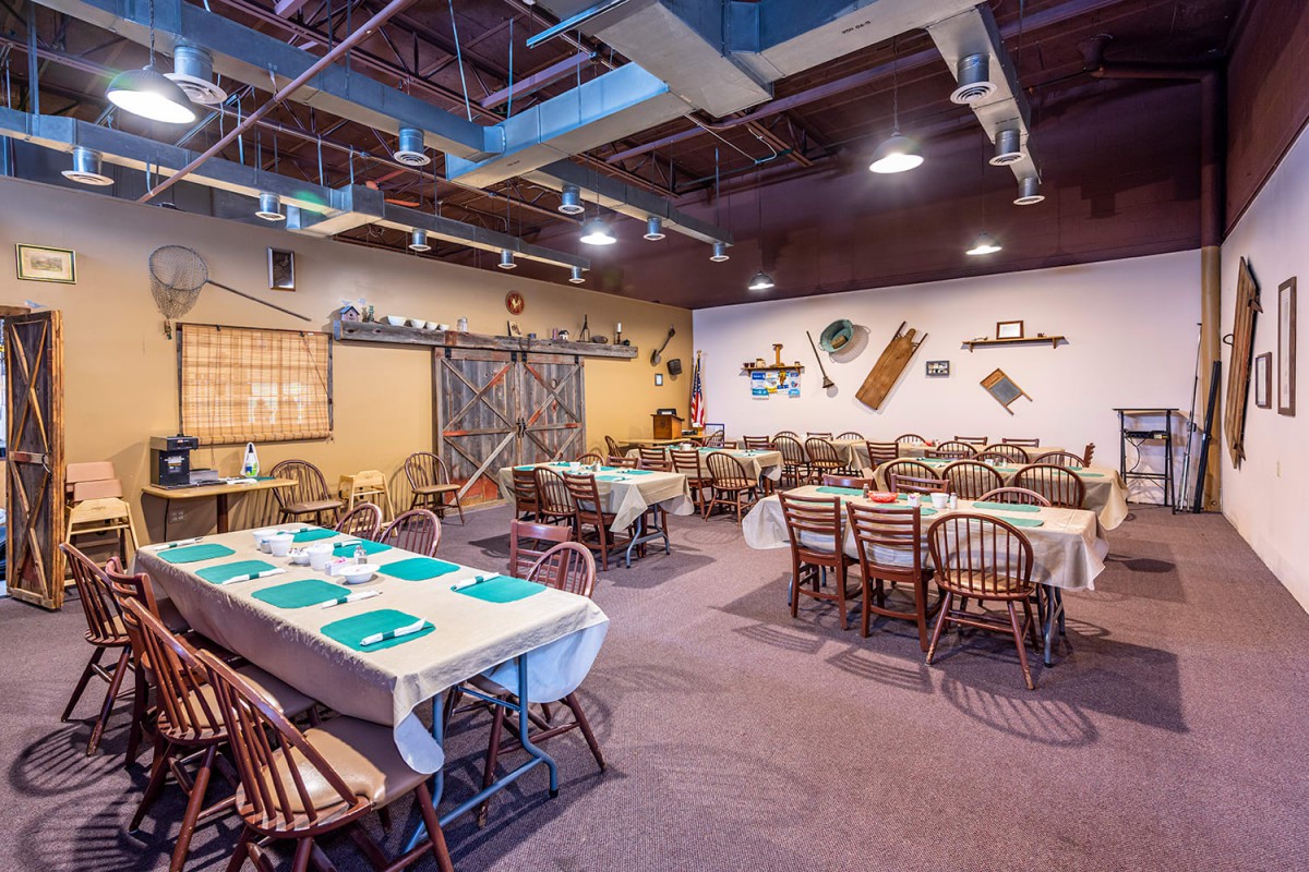 A cozy restaurant dining area with neatly arranged tables and chairs, featuring rustic decor on the walls.