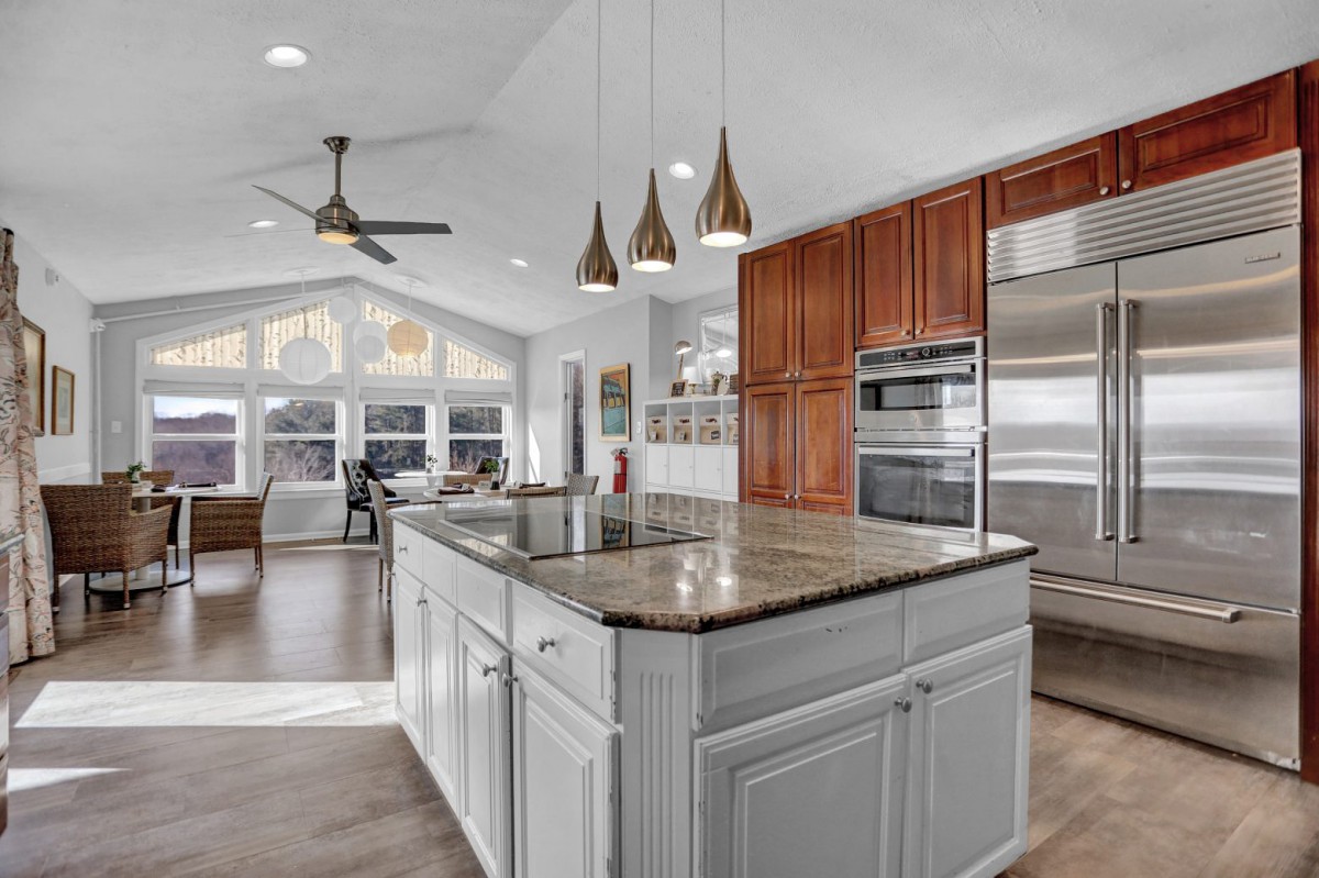 Modern kitchen with a central island, granite countertops, and stainless steel appliances.