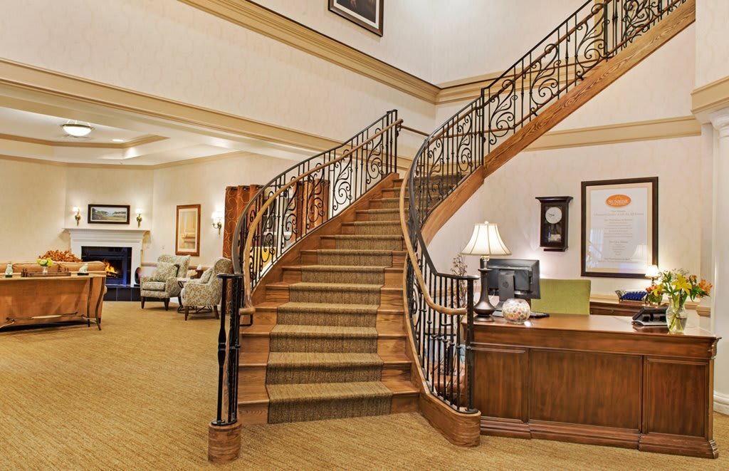 A luxurious hotel lobby featuring a grand curved staircase.