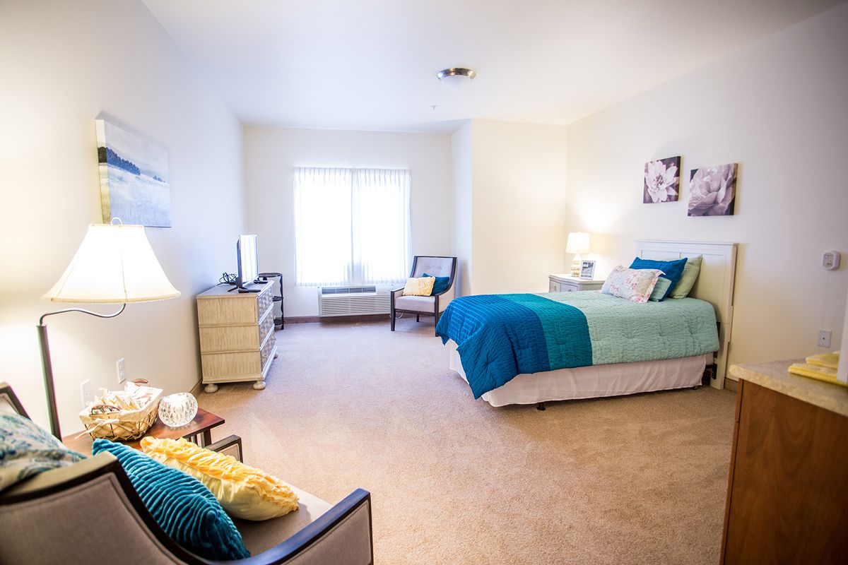 A bright and modern bedroom with stylish decor, featuring a comfortable bed and seating area.