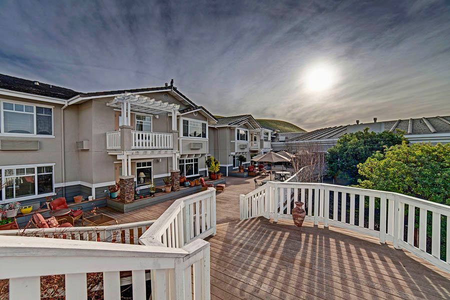 A serene residential area with houses featuring balconies under a setting sun.