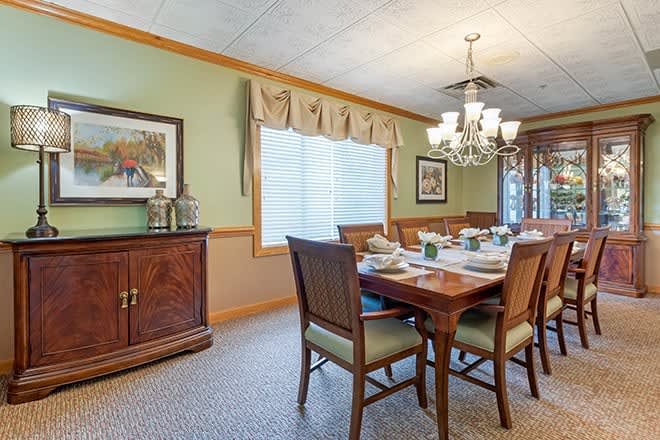 A classic dining room setup with a wooden table, chairs, and a chandelier.