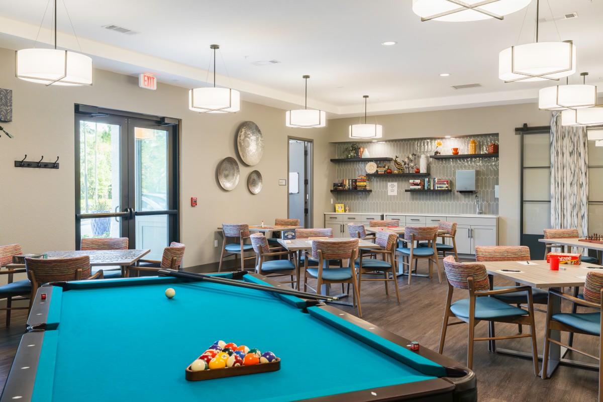 A modern recreation room featuring a pool table and comfortable seating area.