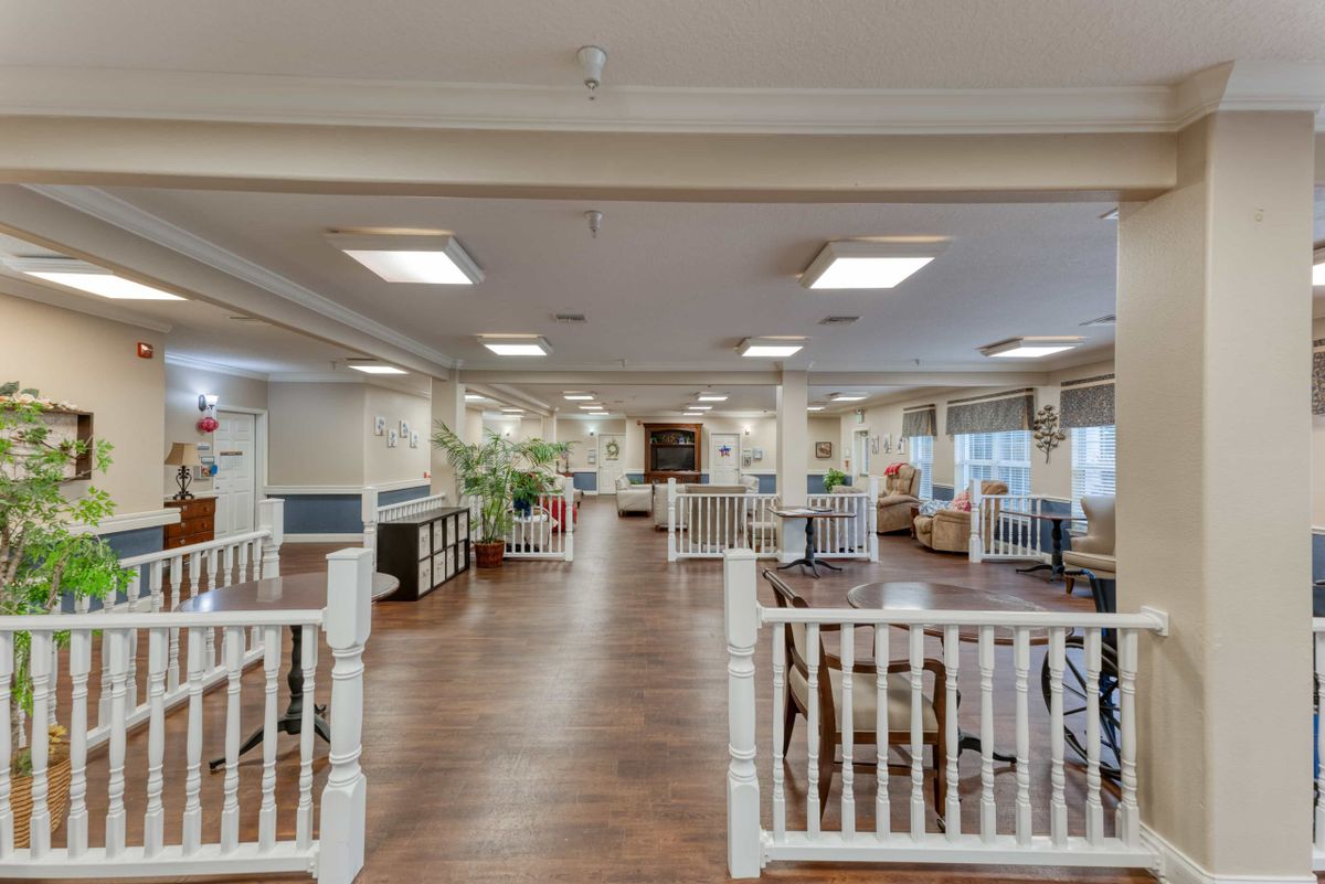 A spacious, well-lit interior room with wooden flooring and various furnishings.