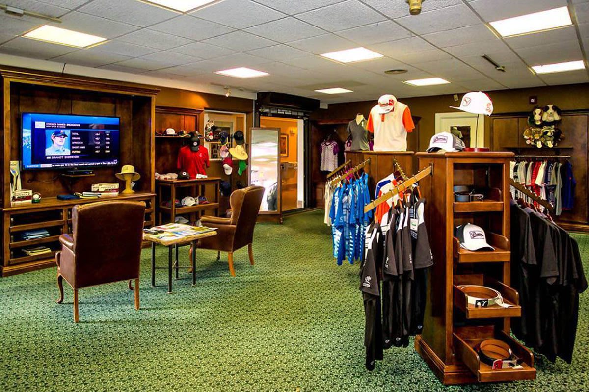A well-organized golf shop featuring clothing and equipment displays.