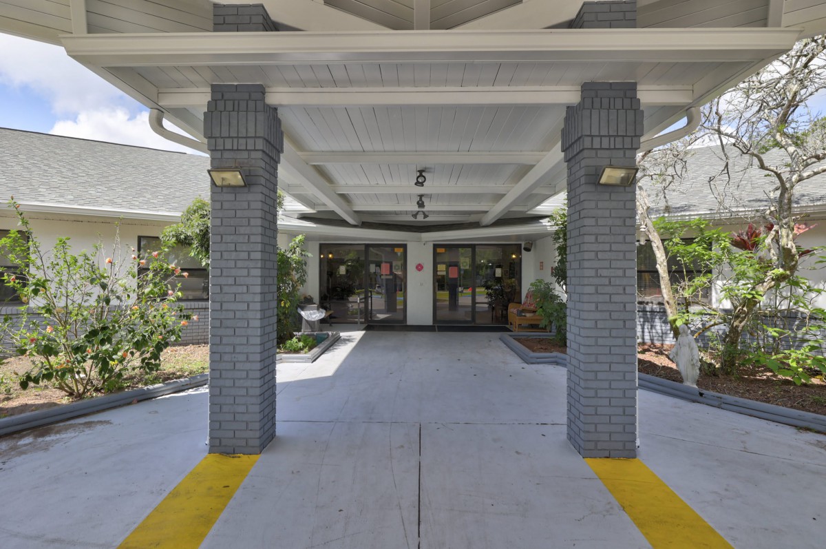 The image shows the entrance to a building with columns and a covered walkway.