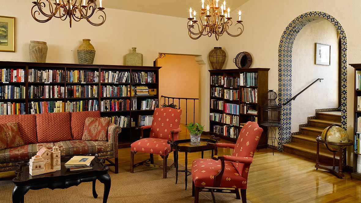 A cozy library with comfortable seating and shelves filled with books.