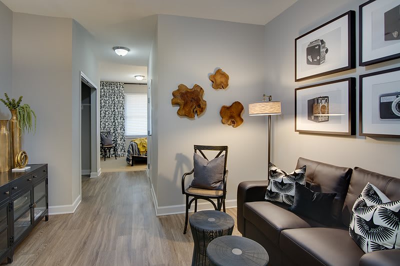 A modern living room with contemporary artwork, comfortable seating, and wooden floors.