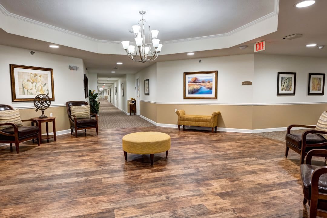 A well-lit hallway with wooden flooring and elegant furnishings.