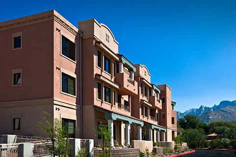 A modern residential apartment complex under a clear blue sky.