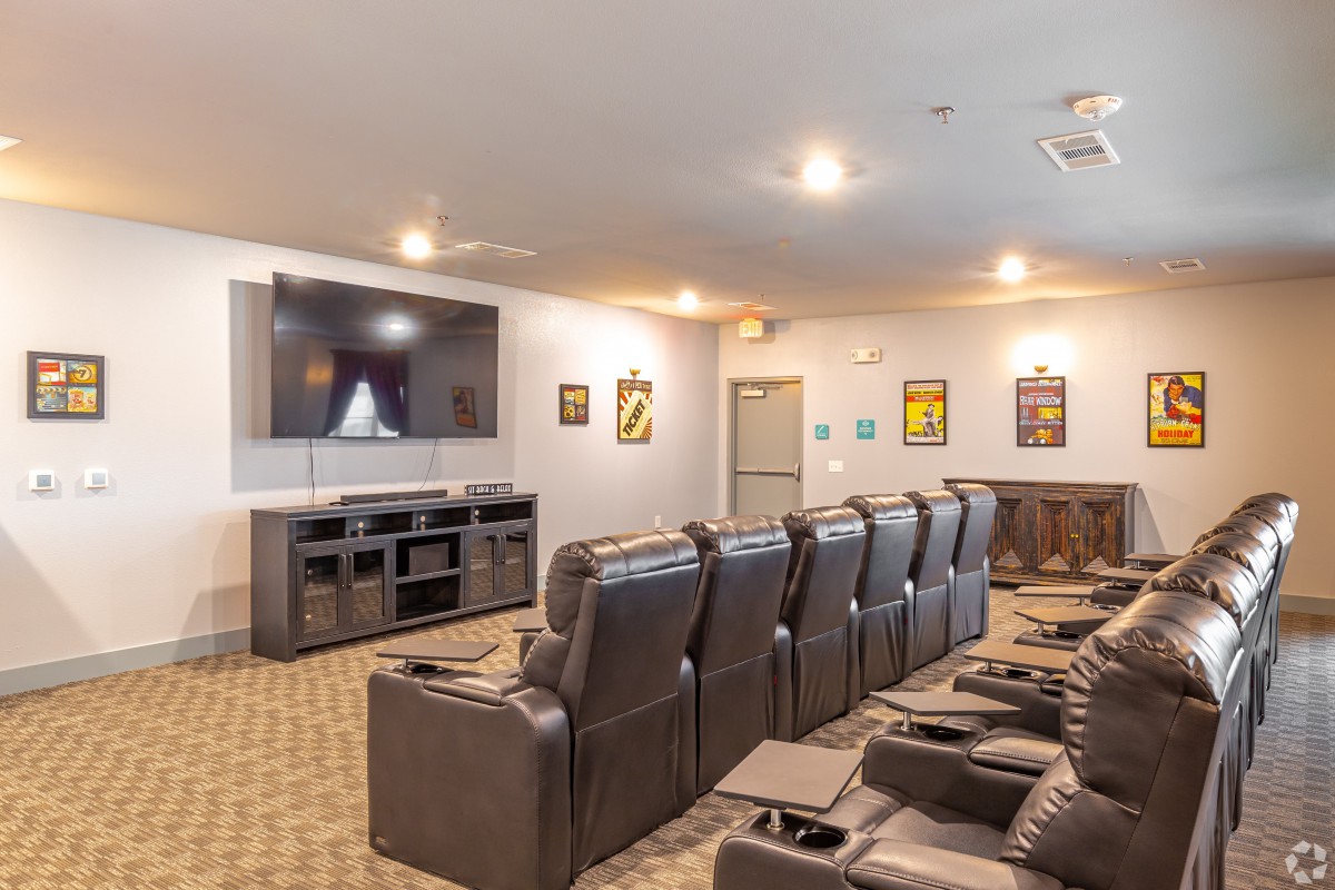 A cozy home theater room with comfortable seating and a large screen for viewing.