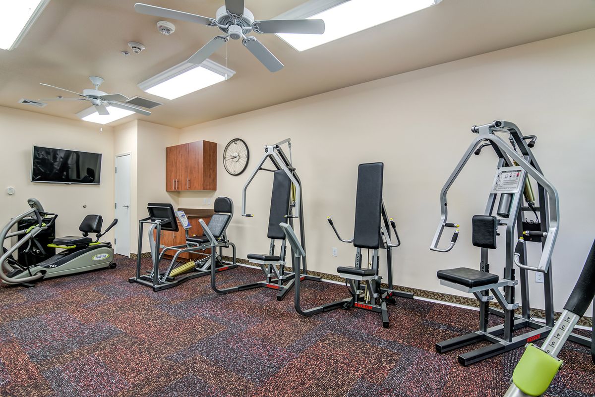 A gym room equipped with various exercise machines and fitness equipment.