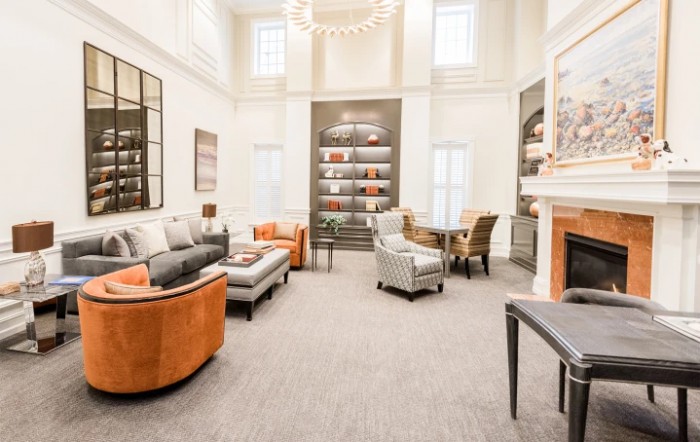 A modern and bright living room with comfortable seating, a bookshelf, and a fireplace.
