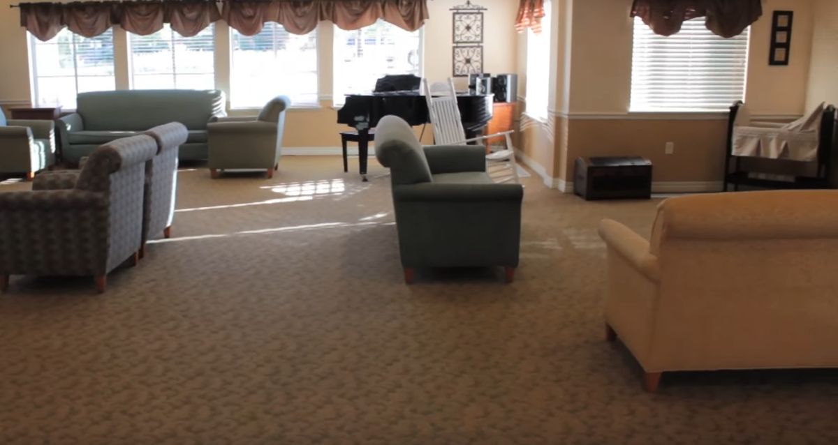 A cozy living room with a piano and comfortable seating.