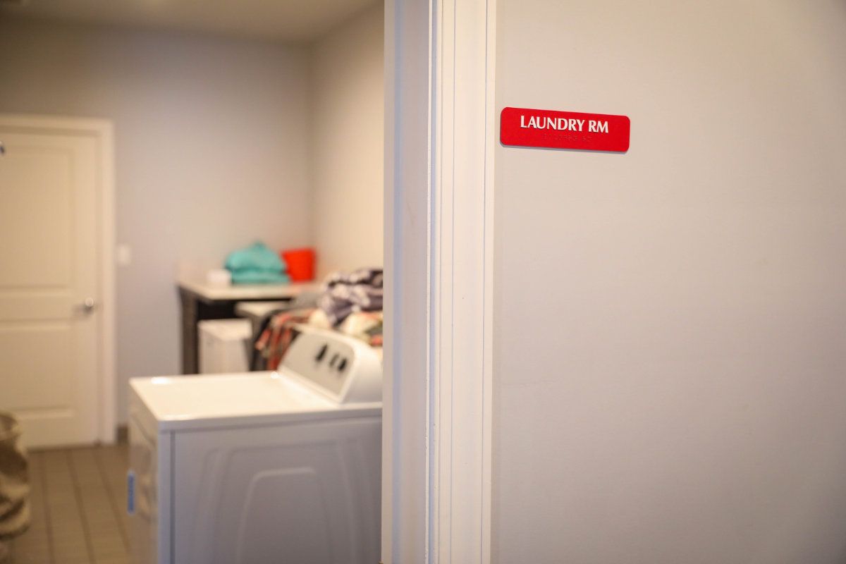 A laundry room with a washing machine and neatly folded clothes.