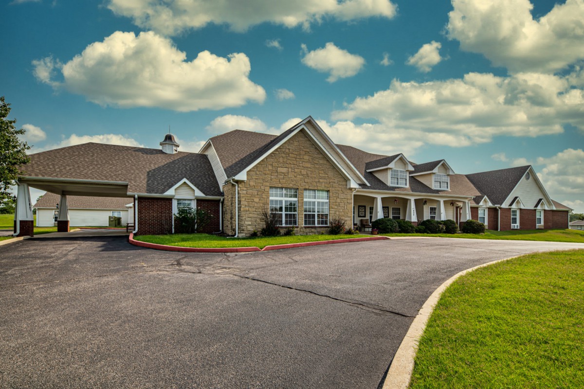A suburban residential building under a partly cloudy sky.