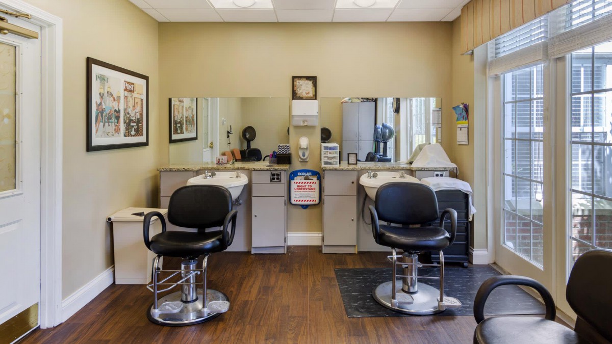 An interior view of a barbershop with two salon chairs facing mirrors.
