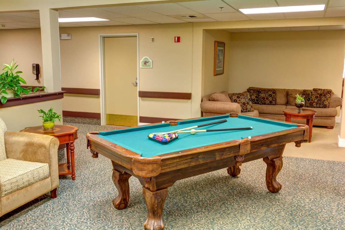 A cozy recreational room featuring a pool table and couches.