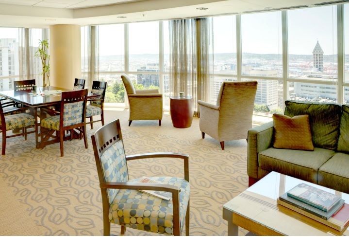 A spacious lounge area with comfortable seating and city views.