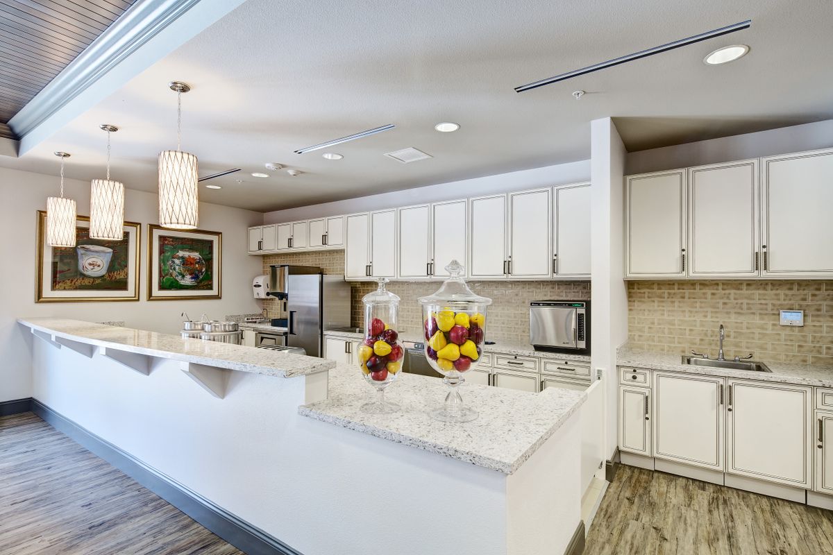 A modern kitchen interior with white cabinets and a sleek countertop.