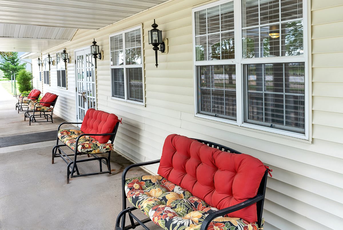 A comfortable porch with cushioned chairs and lantern lighting.