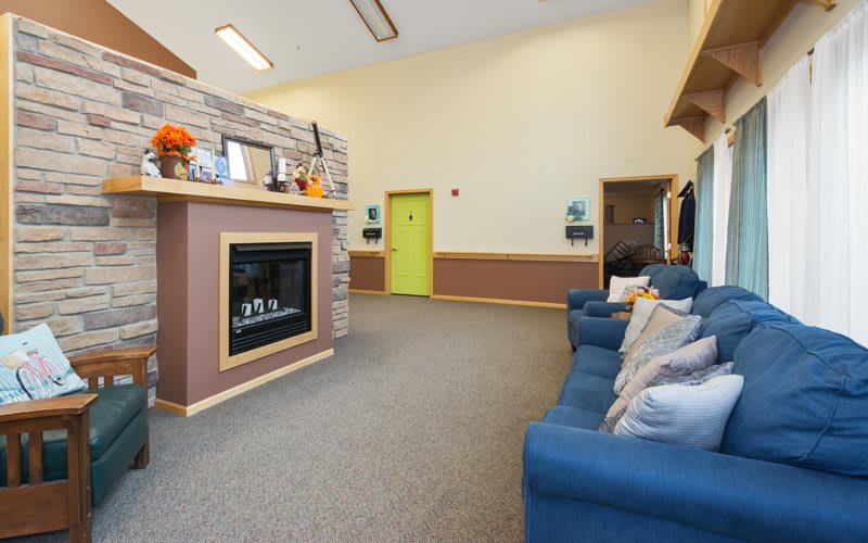 A cozy living room featuring a fireplace and comfortable sofa seating.