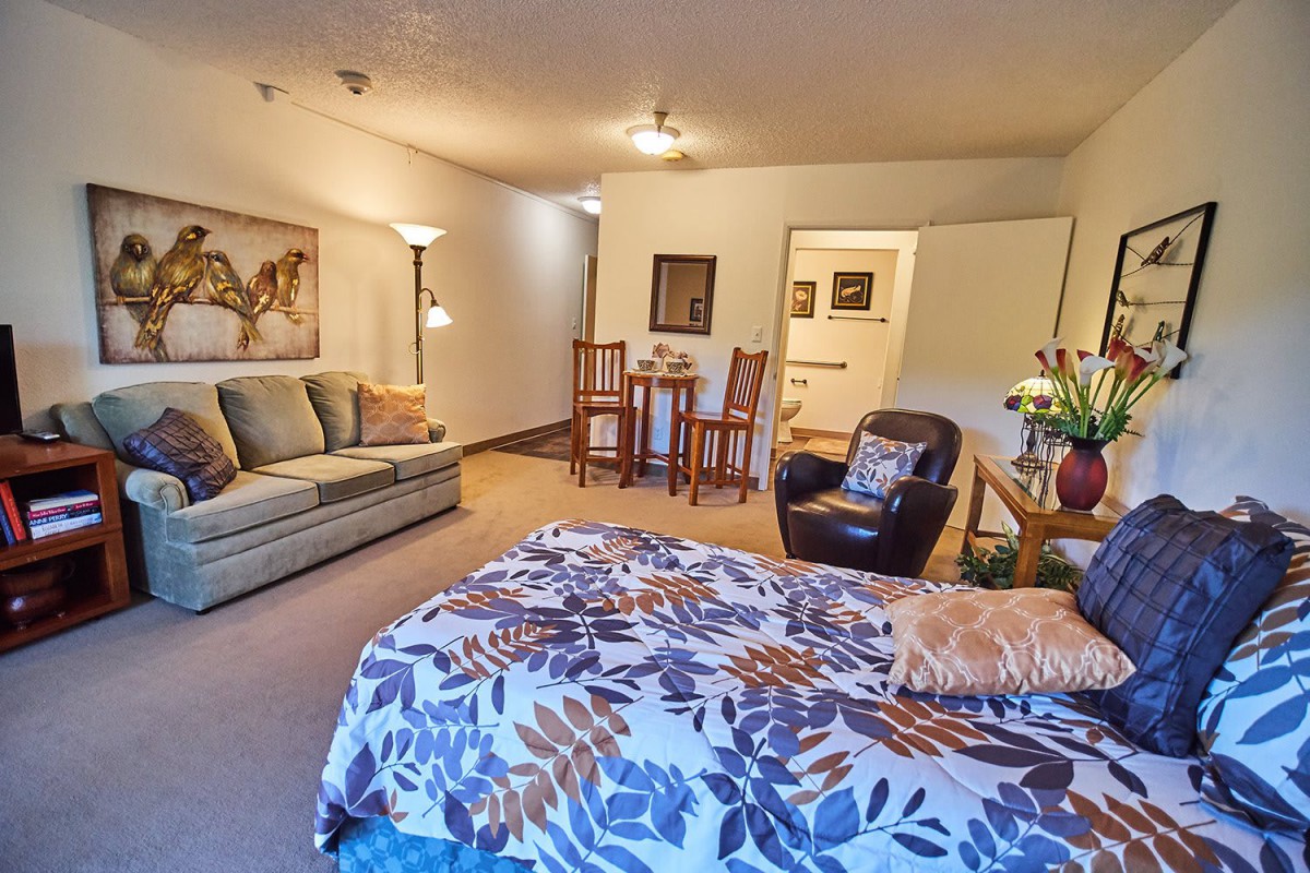 Spacious living area with a cozy arrangement of furniture including a sofa, armchair, and dining set.
