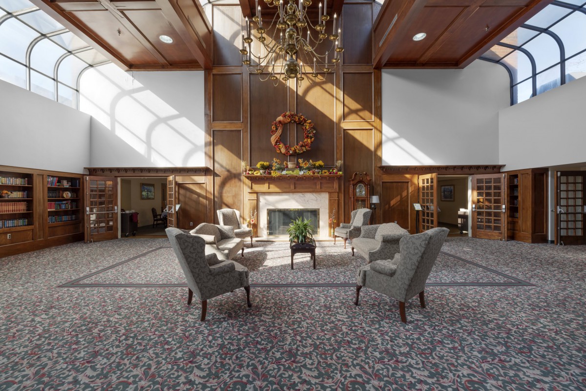 A spacious and elegant lobby with comfortable seating, a grand chandelier, and a fireplace.