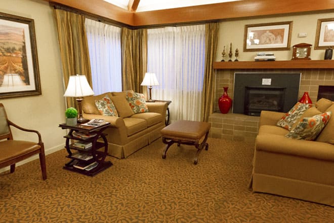 A cozy living room features warm lighting, plush sofas, and a fireplace for an inviting atmosphere.