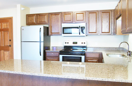 A modern kitchen featuring a combination of brown cabinetry and white appliances.