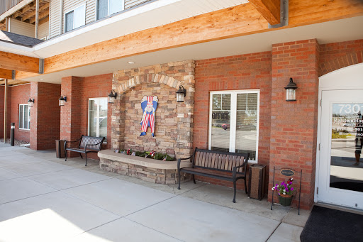 A charming exterior view featuring stone accents, benches for relaxation, and decorative artwork.