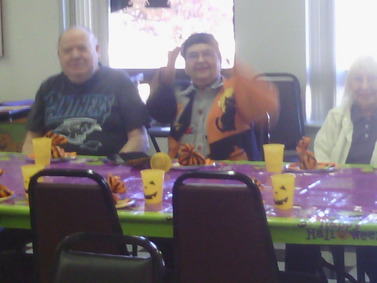 A group of people sitting around a decorated table at a celebration.