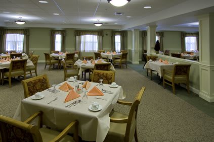 A spacious dining area with neatly arranged tables and chairs, featuring elegant table settings.
