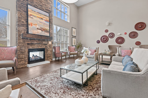 A beautifully designed modern living room featuring a cozy fireplace, elegant furniture, and abundant natural light.