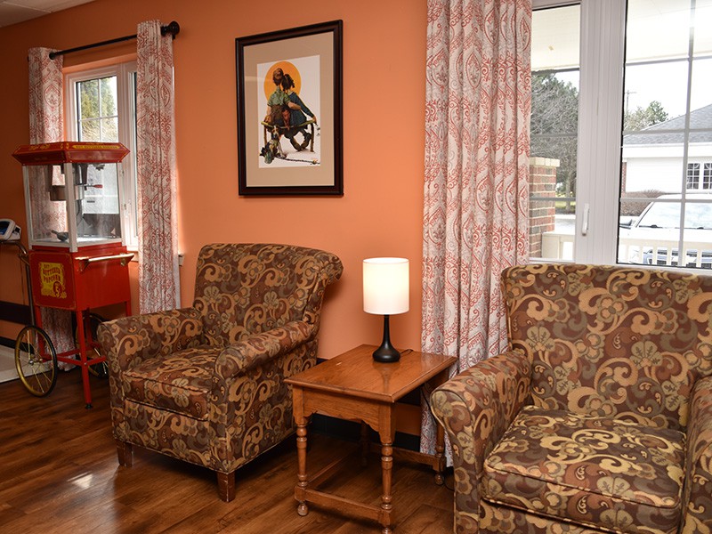 Cozy living room with patterned armchairs and warm orange walls.