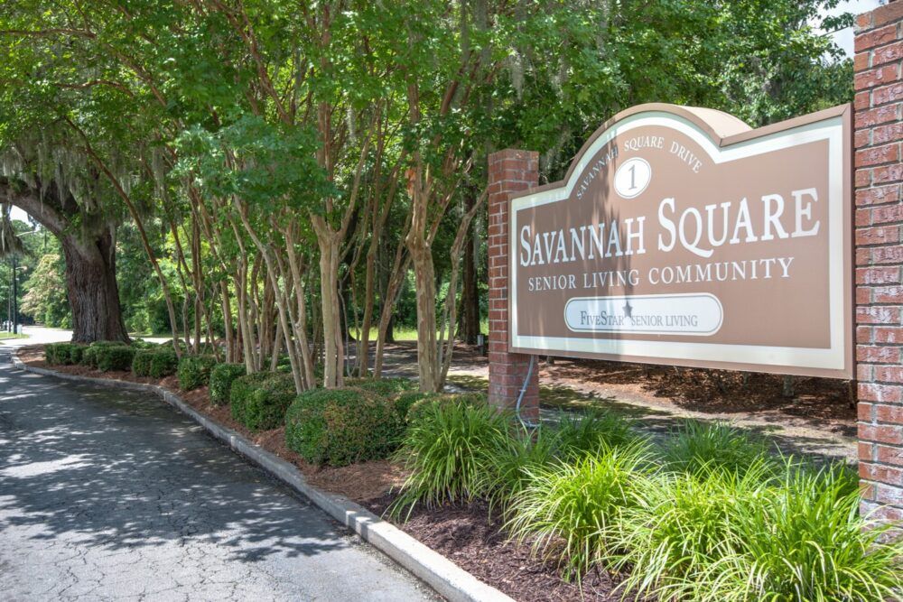 Entrance sign for Savannah Square, surrounded by trees and greenery.