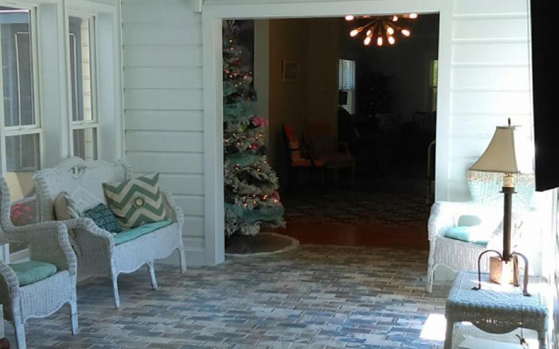 A cozy living room decorated for the holidays with a Christmas tree and modern lighting.