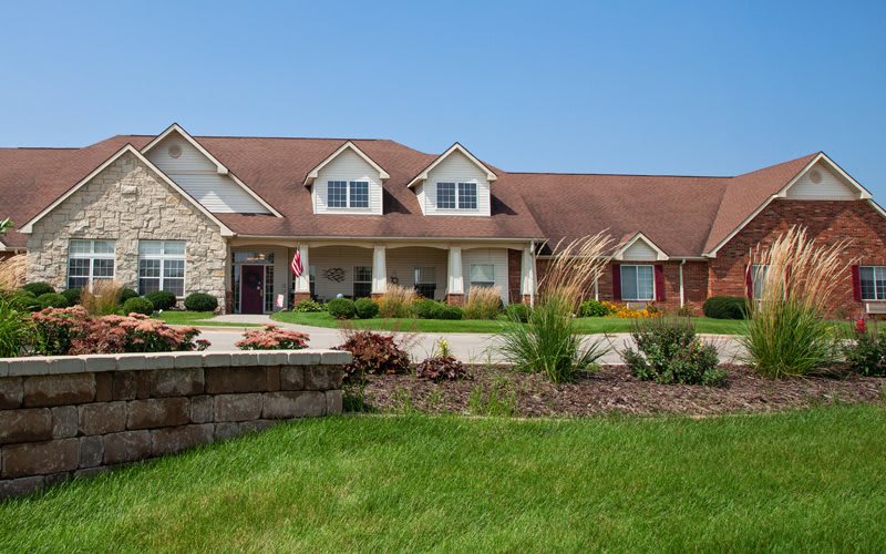 A large suburban house with a well-maintained lawn and landscaping.