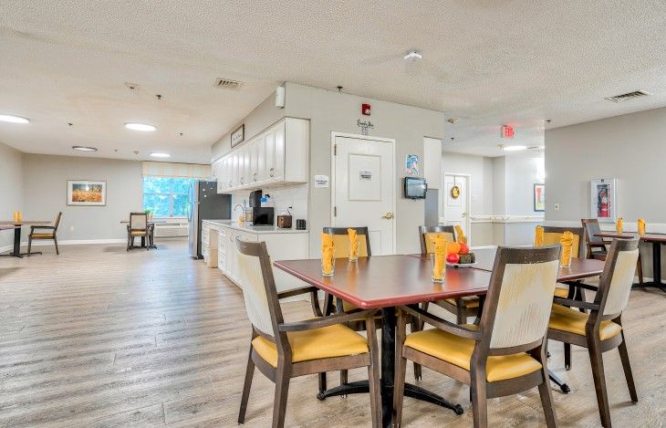 A cozy dining area with wooden floors and a kitchen in the background.