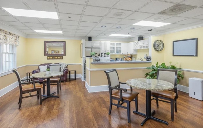 A cozy cafe interior with seating and a kitchen area.