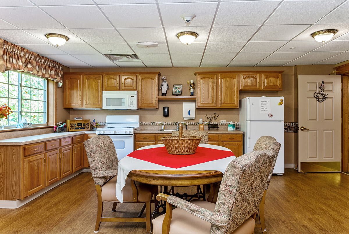 A cozy kitchen with wooden cabinets, a dining table, and modern appliances.