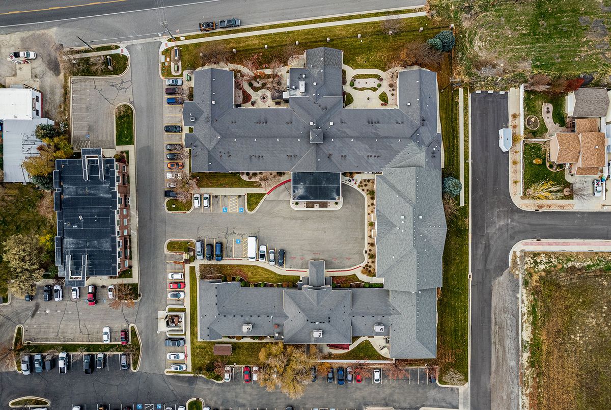 Aerial view of a building complex with surrounding parking and landscaped areas.