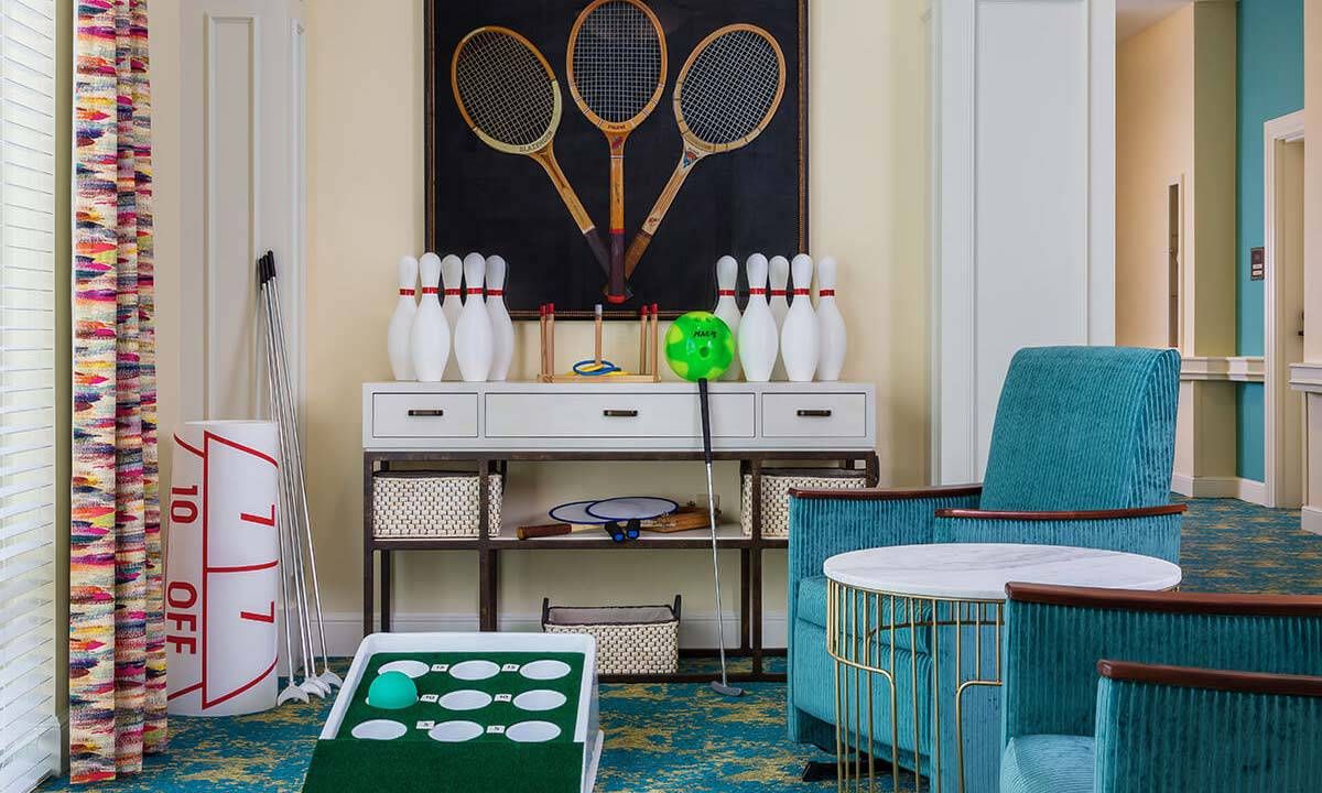 A stylish game room with retro decor featuring vintage tennis rackets and bowling pins.