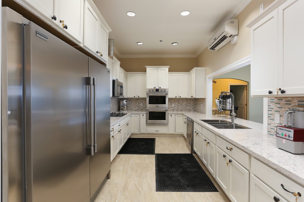 A modern kitchen with sleek appliances and white cabinetry.