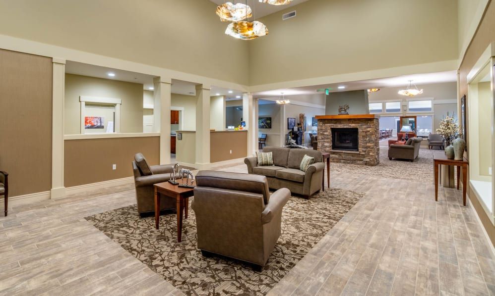 A modern lobby featuring comfortable seating and a central fireplace.