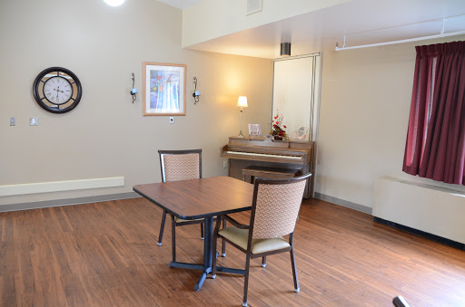 A cozy dining area featuring a table and two chairs, with warm lighting and a minimalist design.