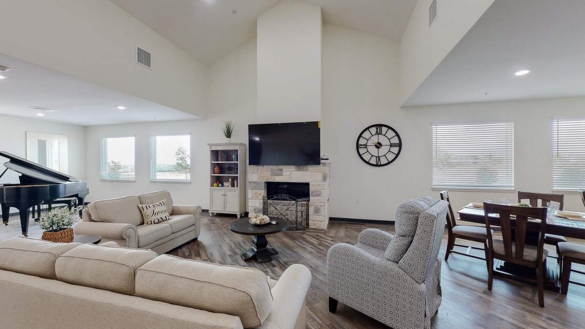 A modern living room with a fireplace, TV, and comfortable seating.